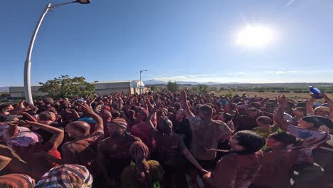 guadix festival of cascamorras 2024. crowd of people covered in colors jumping will chanting songs