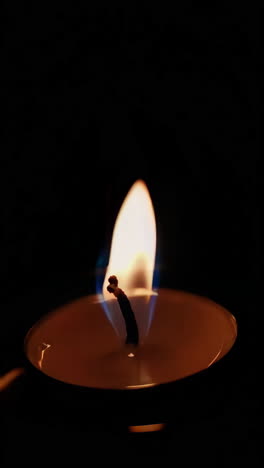 una vela ardiendo en la oscuridad