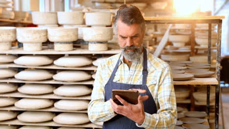 male potter using digital tablet 4k