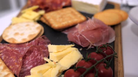 Starter-platter-with-cheese,-crackers,-salami-and-tomato