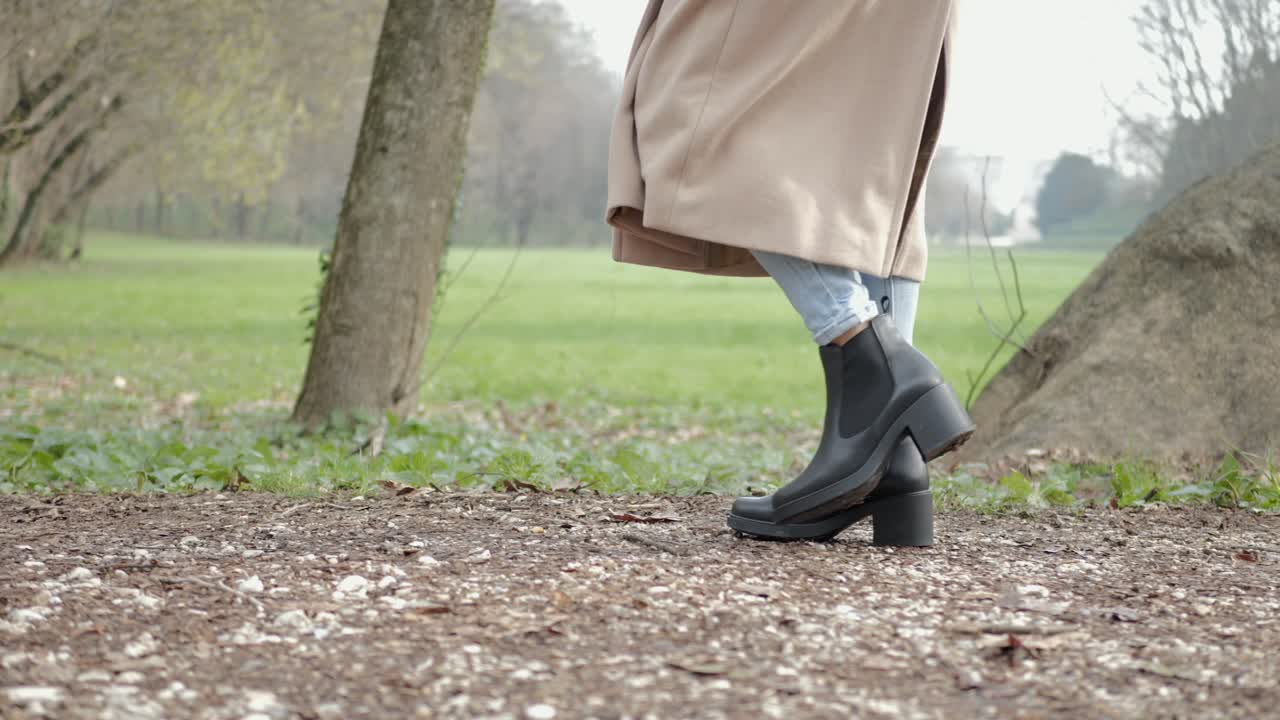 Woman walking in the main avenue of Querini park in Vicenza, Italy.
