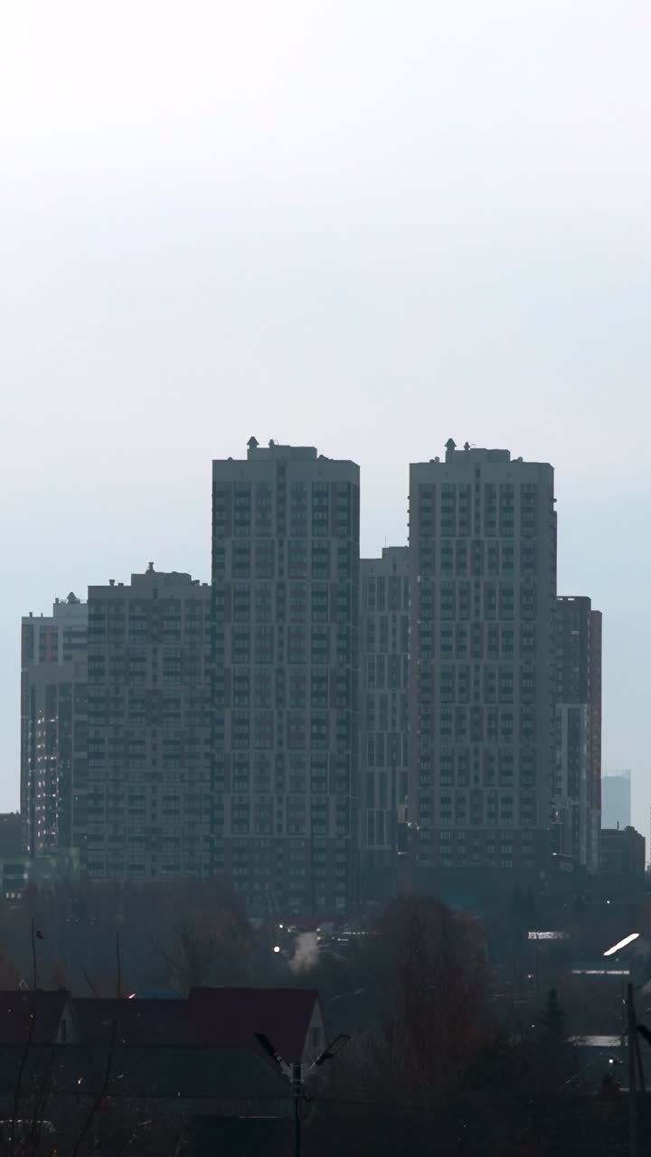 Vista lejana de edificios residenciales modernos en un paisaje urbano brumoso