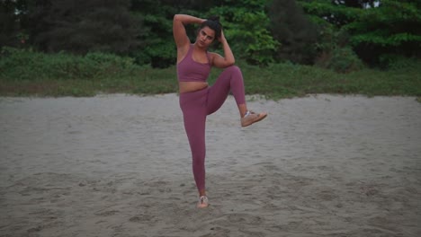 silueta joven practicando yoga en la playa, moviendo su cuerpo armoniosamente