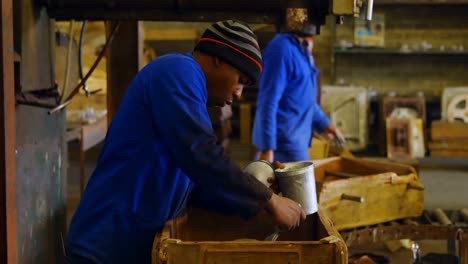 male worker painting metal casting in workshop 4k