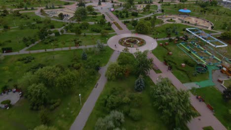 Aerial-view-over-the-Molodizhnyy-Park-towards-the-Koledzh-Khoreohrafichnoho-Academy,-in-Troieshchyna-district,-cloudy-day,-in-Kiev-city,-Ukraine---tilt-down,-drone-shot