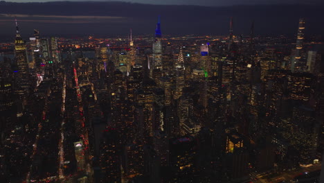 Volar-Hacia-Atrás-Sobre-La-Ciudad-De-La-Noche.-Imágenes-Panorámicas-Aéreas-De-Los-Rascacielos-Del-Centro.-Manhattan,-Ciudad-De-Nueva-York,-Estados-Unidos