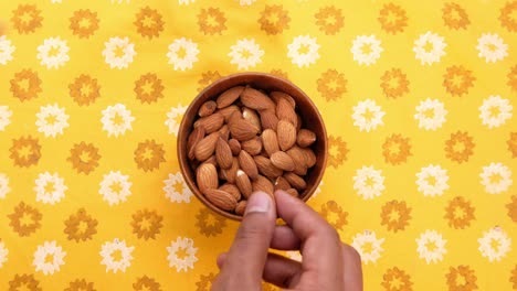 almendras en un tazón de madera en un mantel amarillo