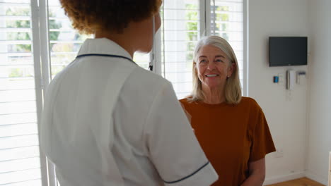 enfermera con uniforme escuchando el pecho de una paciente de edad avanzada en una habitación privada del hospital