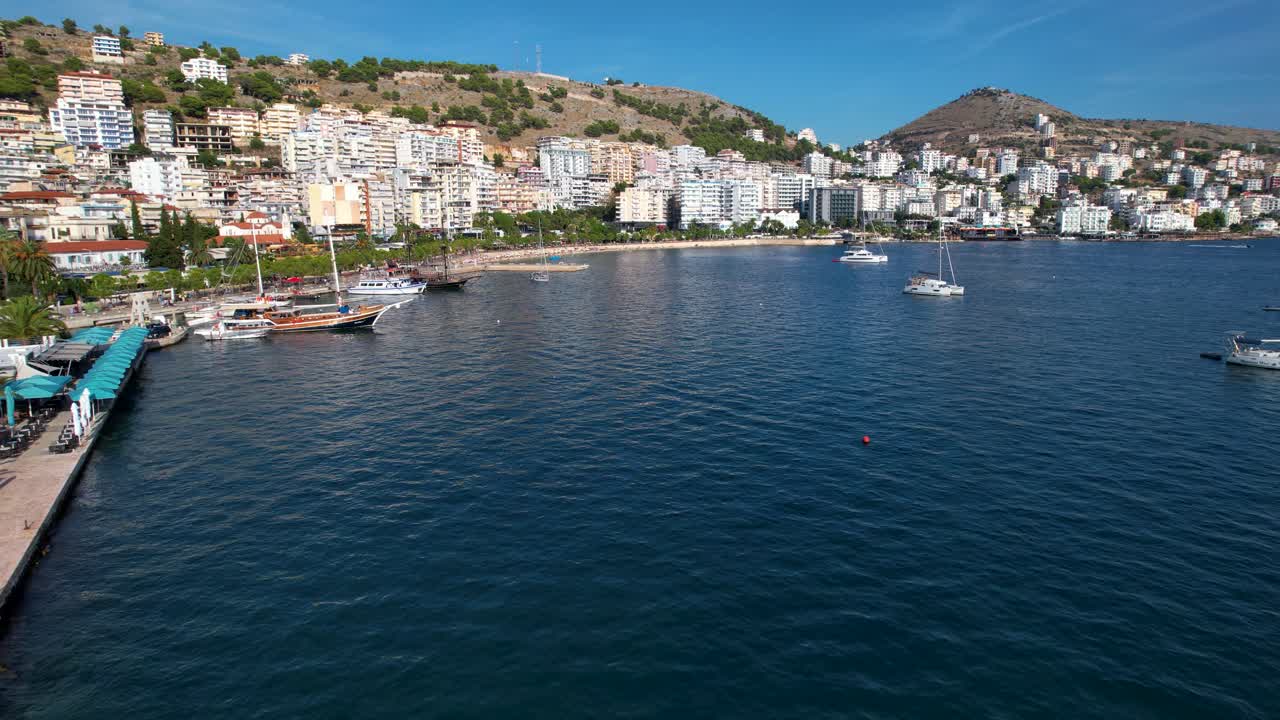 Saranda Coastal City Bay Picturesque Scene with Pier, Promenade, Hotels, Tourist Destination by the Deep Blue Sea