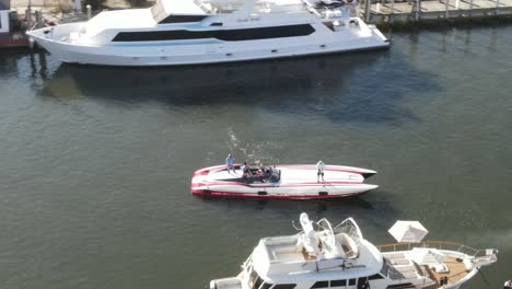 people ride and stand on powerboat floating on sunlit waters in the marina