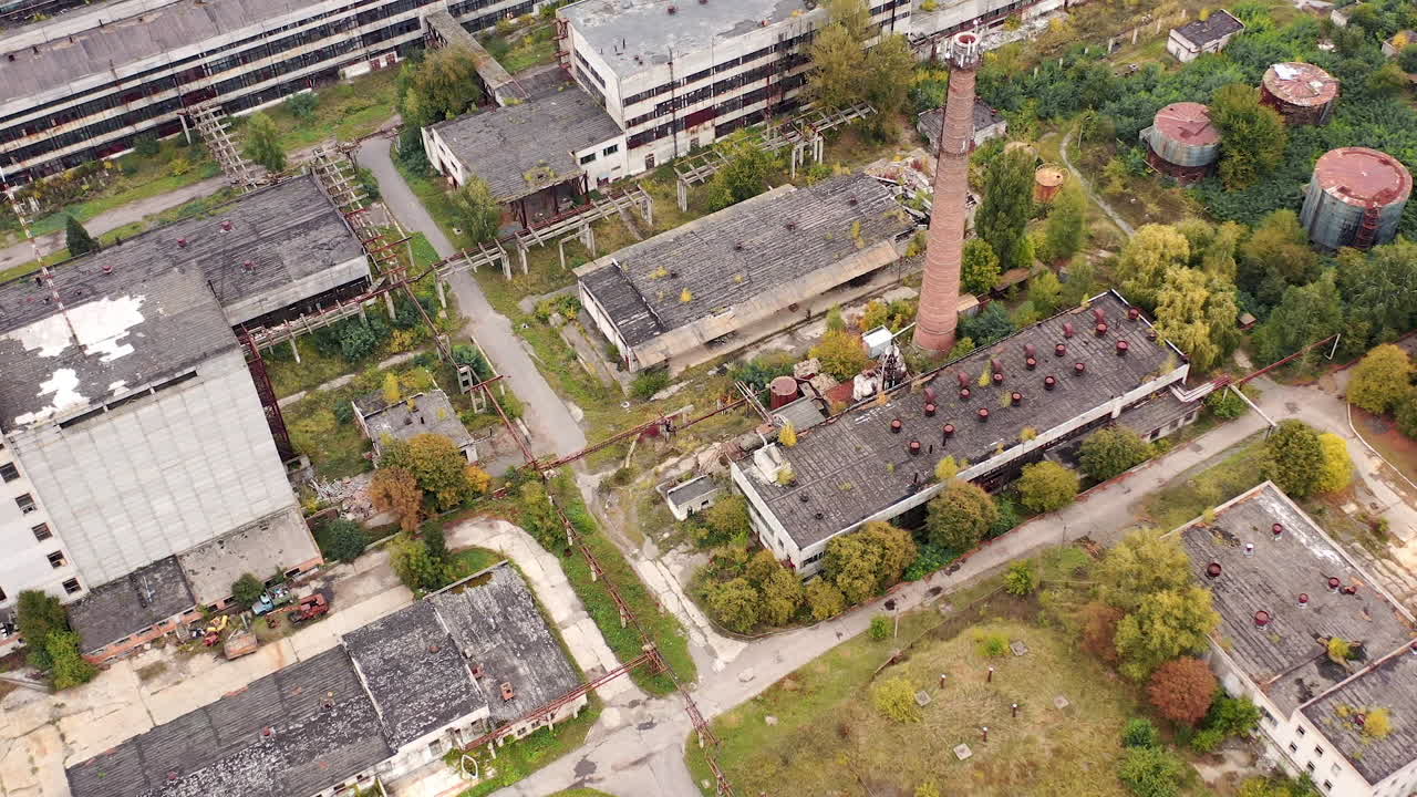 Old industrial area. Abandoned buildings with old roofs. Destructive architecture of old factory. Aerial view.
