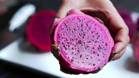 Hands-holding-dragon-fruit-Close-up-of-Red-and-white-dragon-fruit-Red-Dragon-Fruit-Slices-and-Cultivating-Exotic-Plants-pitaya