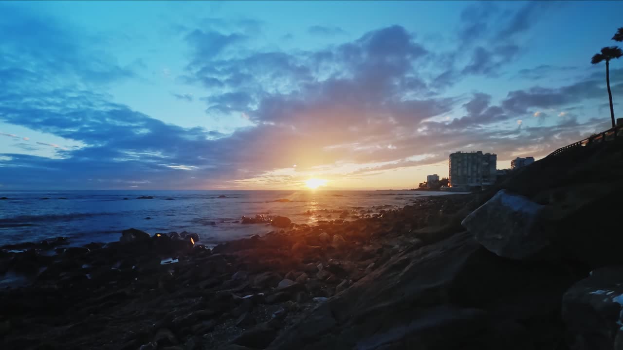 바위 해변에서 흐린 일몰의 극적인 시간 경과