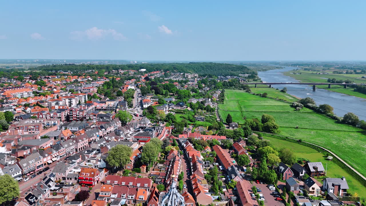Rising over the top of the Cunera Church revealing view on the beautiful scenery of city of Rhenen, Province Utrecht, the Netherlands. Bridge over the river at backdrop.