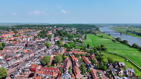 rising over the top of the cunera church revealing view on the beautiful scenery of city of rhenen, province utrecht, the netherlands. bridge over the river at backdrop.