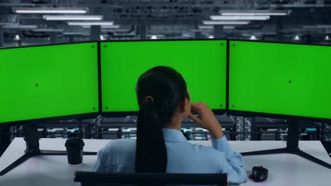 back view of asian woman thinking about something then raising her index finger while working with mock up multiple computer monitor in data center