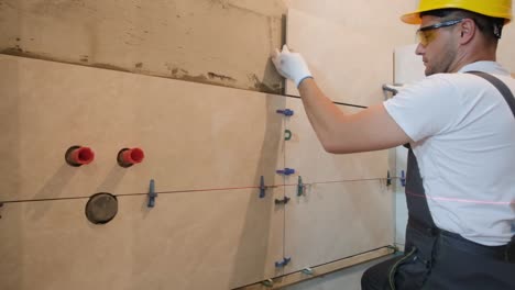 a professional tiler works in the bathroom of a modern house