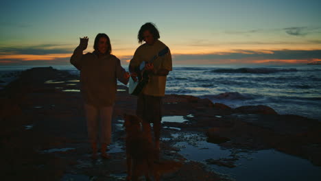 carefree teenagers silhouettes relaxing morning seaside. couple with cute dog