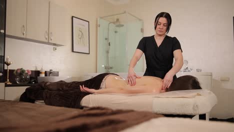 una mujer recibiendo un masaje de espalda en un spa.