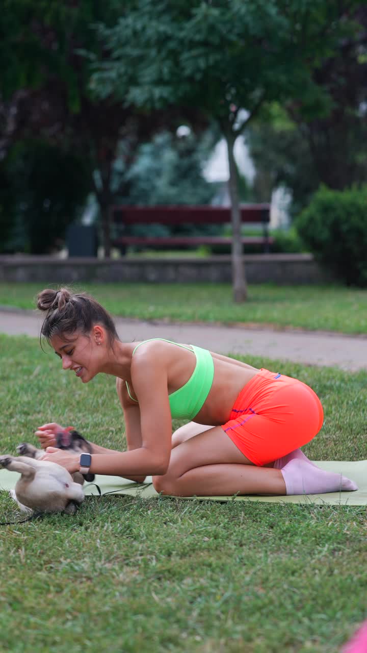 mujer practicando yoga con su cachorro en el parque
