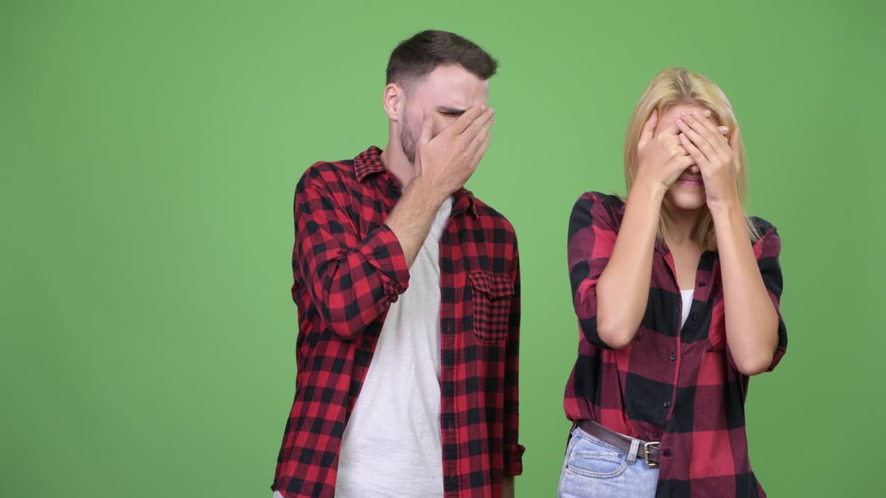 Young couple covering eyes together not wanting to see something