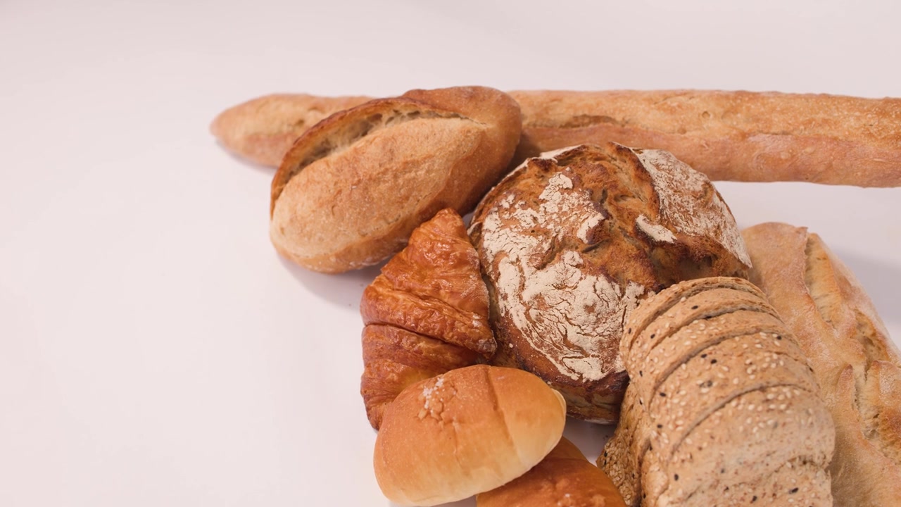 Scatto statico dall'alto di pasta madre, baguette e croissant sotto una luminosa illuminazione da studio.