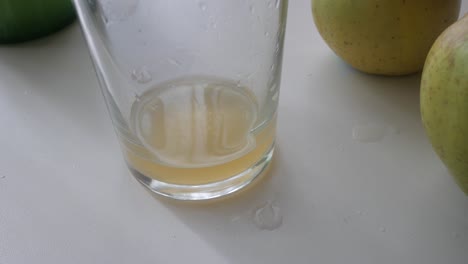 close-up of natural cider in a glass with droplets, highlighting its cloudy appearance