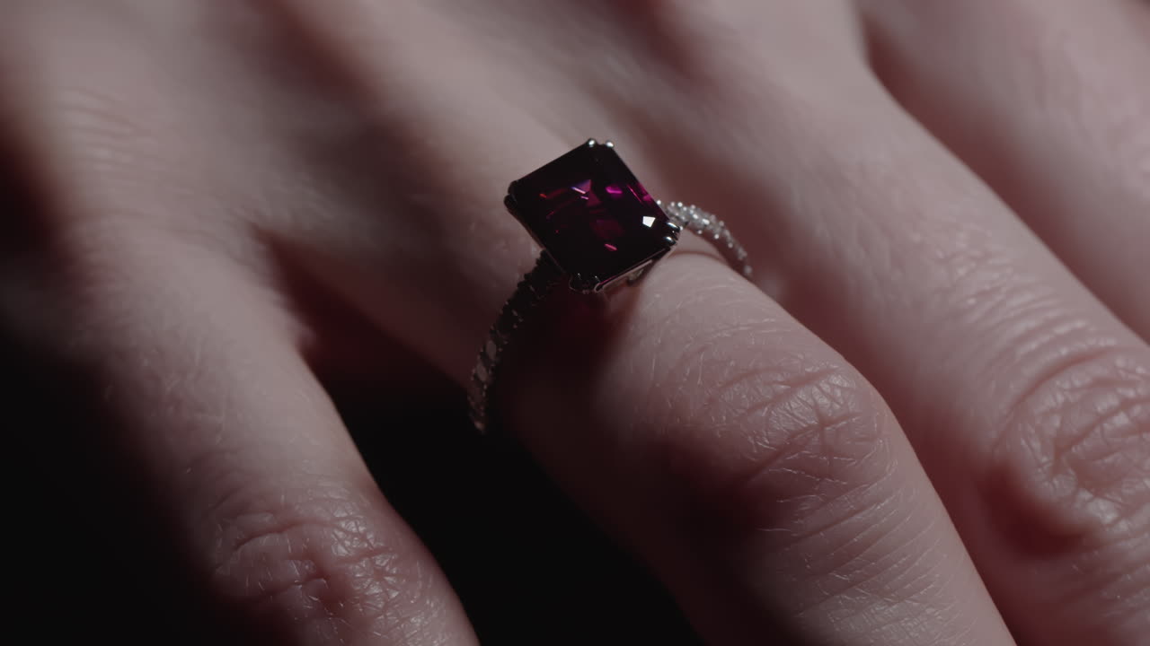Red ruby diamond engagement ring on woman's finger