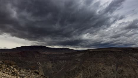 lapso de tiempo estacionario de nubes de tormenta oscuras sobre un cañón desde un mirador en el valle de la muerte