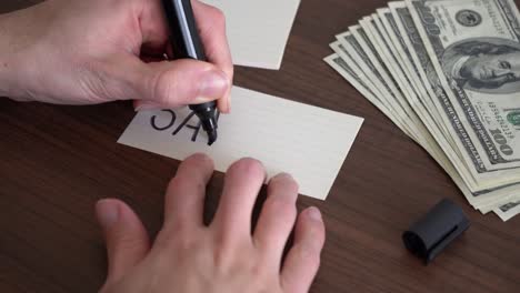 escribiendo la palabra "ahorro" en un pedazo de papel