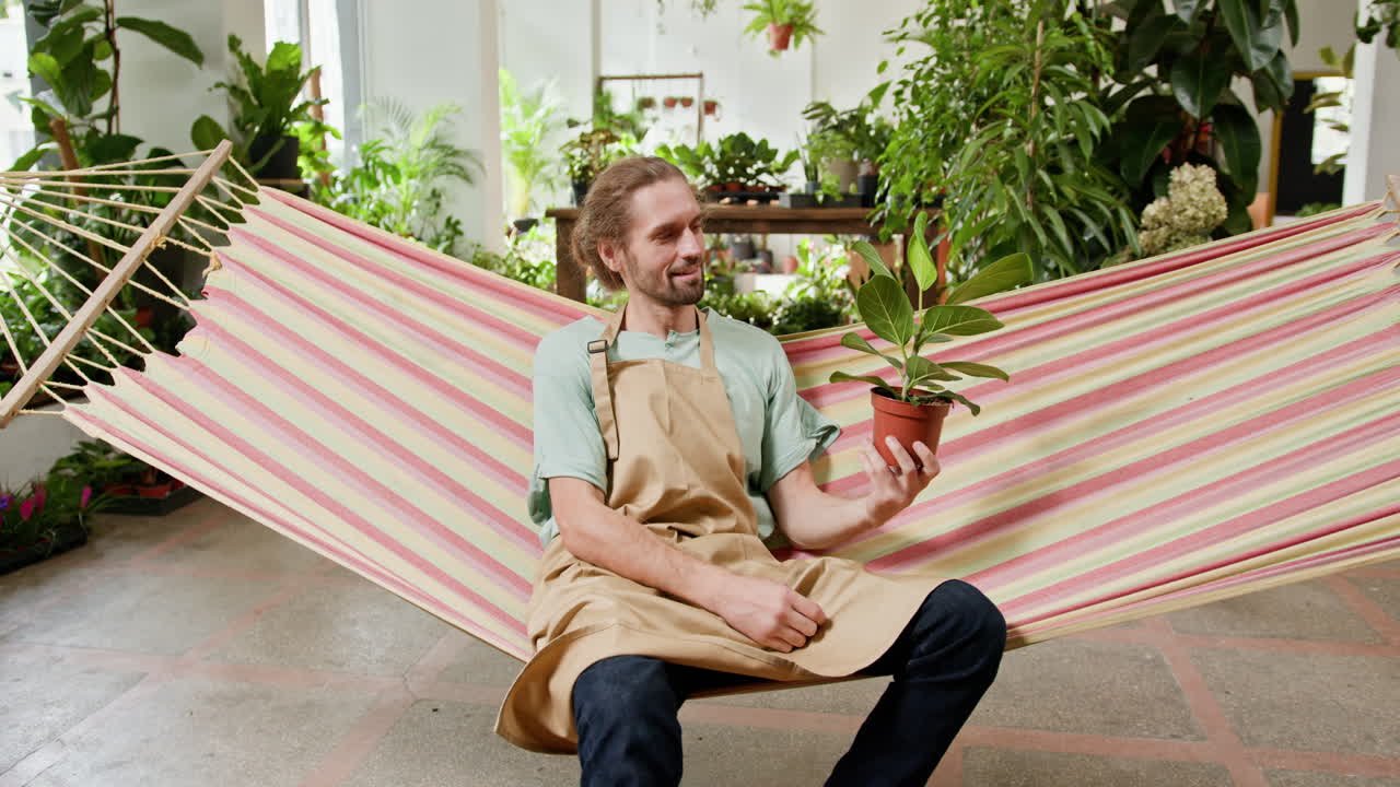 hombre relajándose en una hamaca en una tienda de plantas
