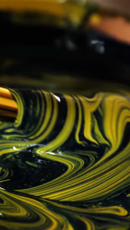 potter mixing paint into bowl