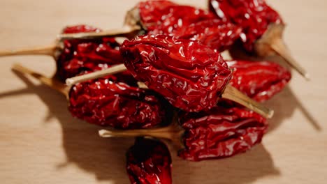 close up of a pile of dried hot peppers lying on a wooden table