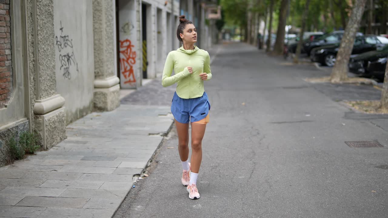 mujer corriendo por la calle de la ciudad