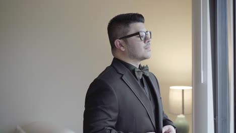 static shot of groom adjusting his suit for his photos before his wedding