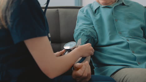 young caring nurse measuring blood pressure and heart rate of elderly man 1