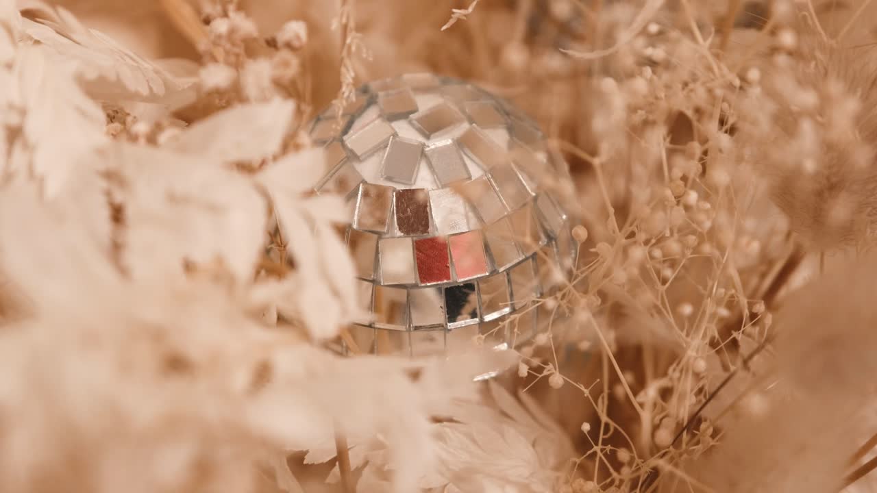 A dry flower arrangement with a small glitter ball as decoration