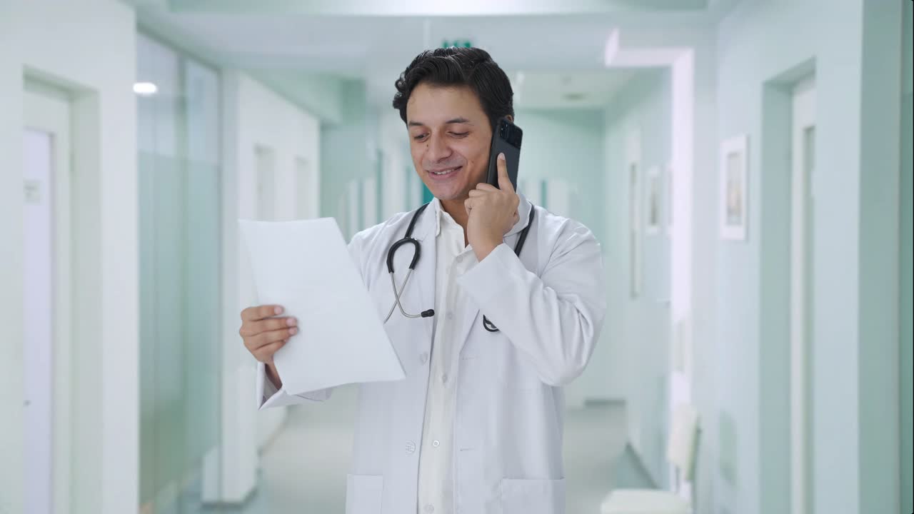 médico indio feliz explicando informe médico en la llamada