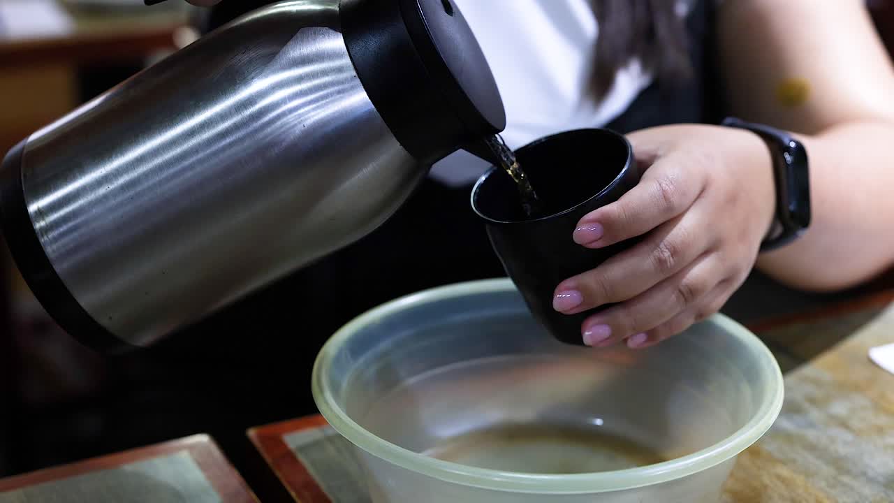 한 사람 이 테르모스 에서 물 을 그 에 부어 놓는다