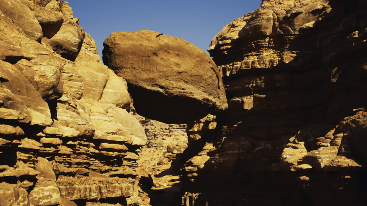 Natural rock formation balancing between canyon walls in the desert