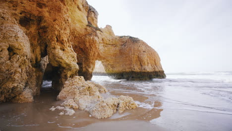 Beach-in-the-Algarve,-Portugal-with-waves-rolling-in-on-a-sunny-day