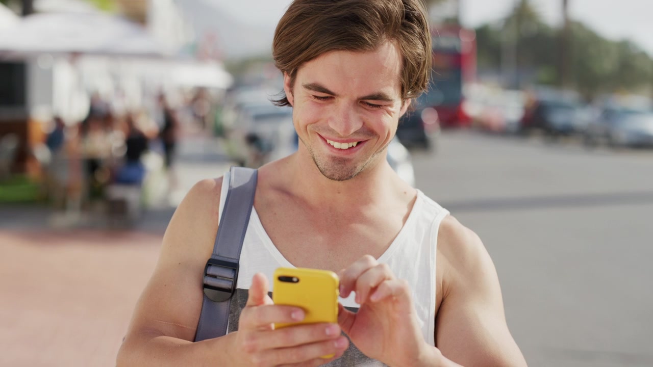 Young Man Using Smartphone on City Street
