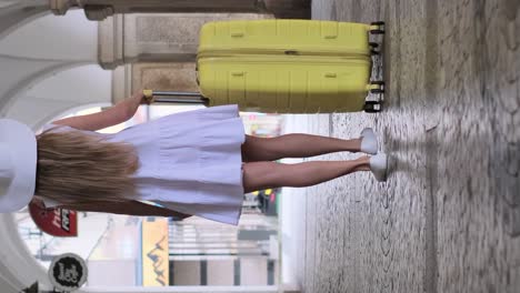 young redhead girl walking with travel suitcase at countryside road. travel destination