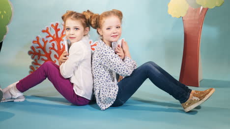 cute little girls are reading books. happy childhood. studio shooting of children
