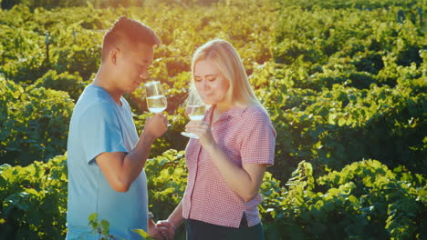 young multi-ethnic couple tasting red wine at the winery private tasting and tourism concept