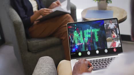 african american businessman using laptop for video call with diverse business colleagues