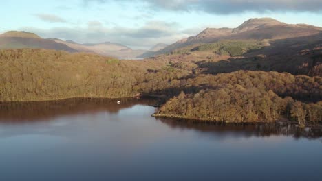 Imágenes-De-Drones-Aéreos-De-Rollo-Izquierdo-De-Las-Montañas-Ben-Lomond-Y-Beinn-Bhreac-Durante-Un-Amanecer-De-Otoño-Con-Bosques-Nativos-De-Hoja-Ancha-Y-Loch-Lomond-En-Loch-Lomond-Y-El-Parque-Nacional-Trossachs