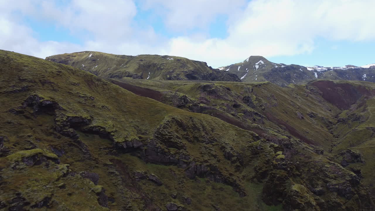 Aerial of pull out over rocky mountains covered with green moss