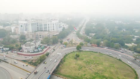 aerial drone shot displaying an overhead view of a curved flyover in delhi, packed with fast-moving vehicles.