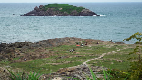 campers with tent exploring on island by ocean on windy stormy day